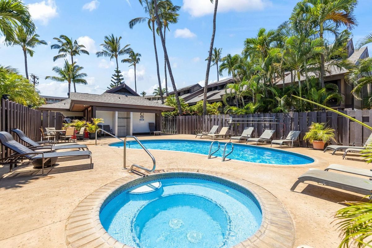 The pool and hot tub set among palms in the tropical grounds at Kihei Resort